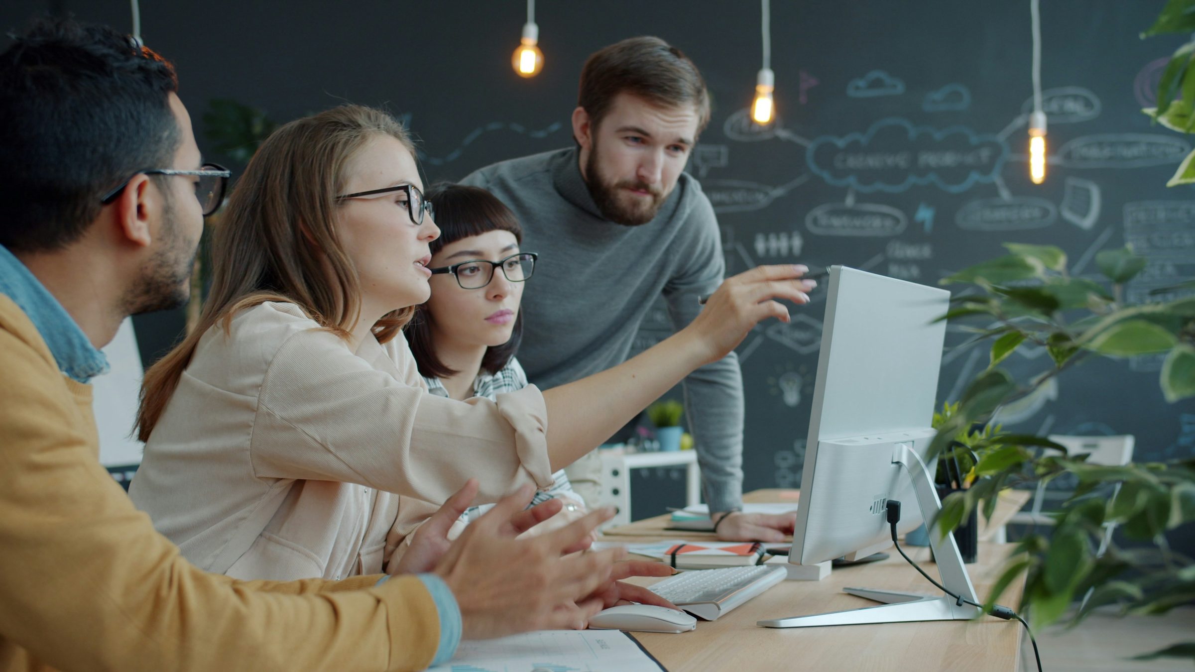 Team collaborating around a computer. Photo: Vitaly Gariev / Unsplash
