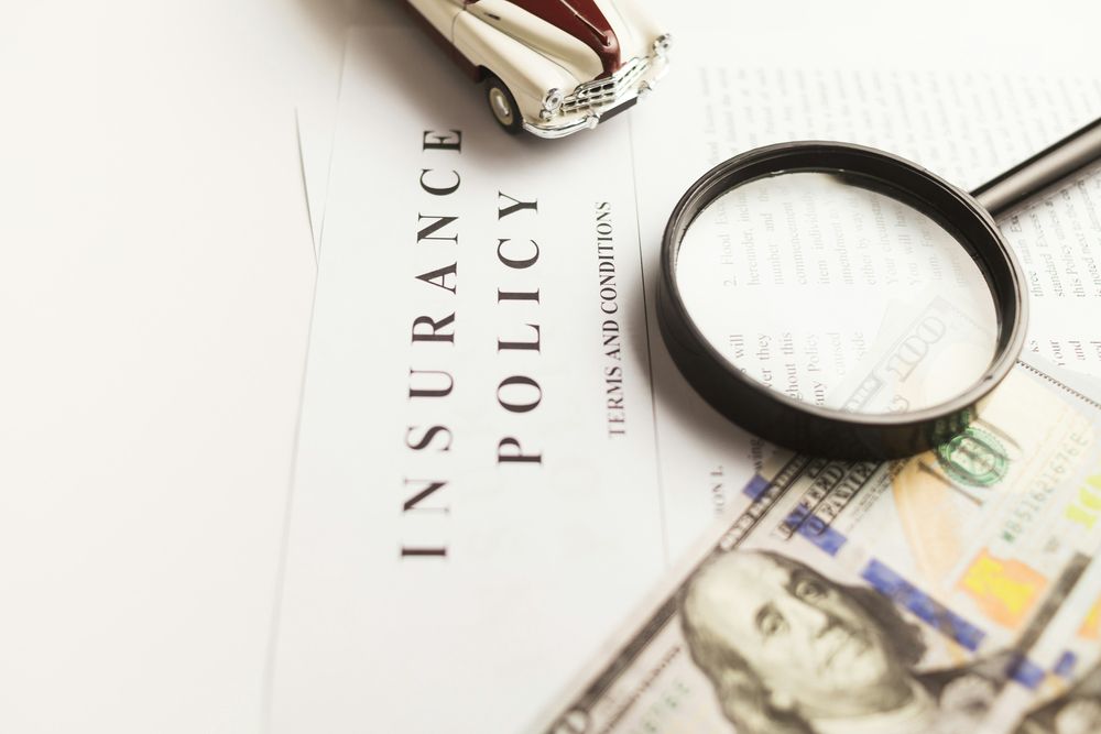 Magnifying glass on an insurance policy. Photo: Vlad Deep / Unsplash