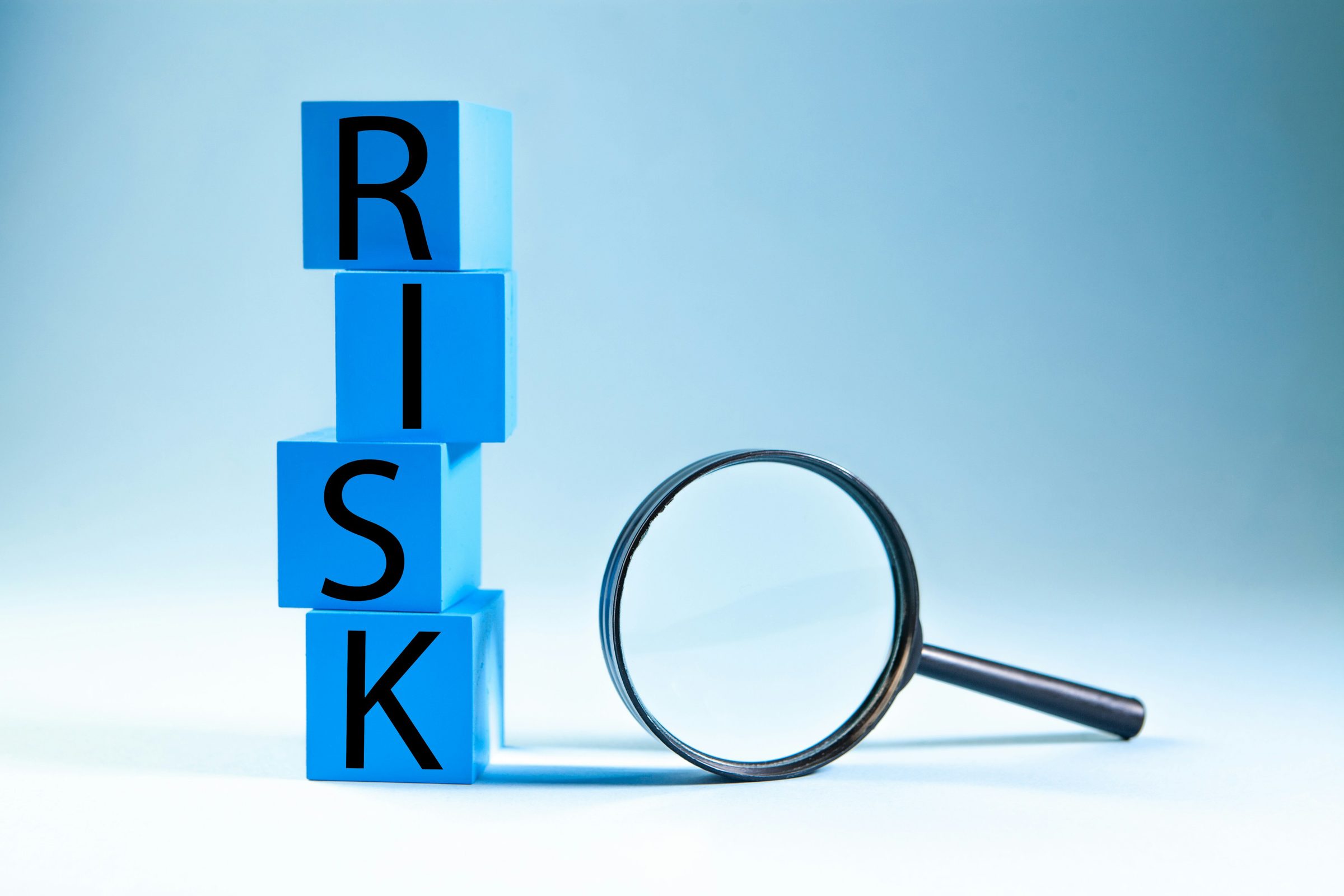 Blocks spelling RISK next to a magnifying glass. Photo: Sasun Bughdaryan / Unsplash