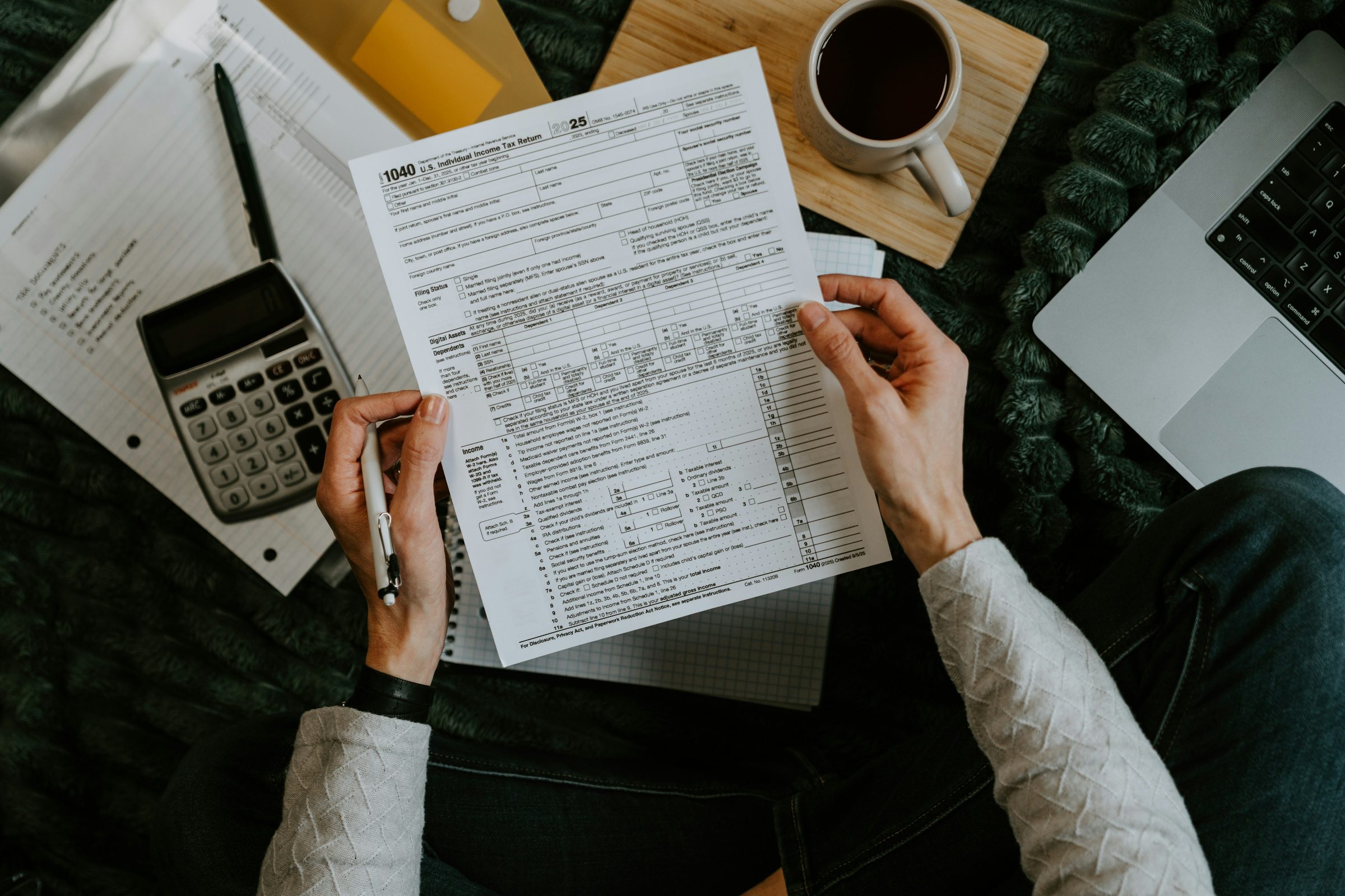 Loan forms with calculator and laptop. Photo: Kelly Sikkema / Unsplash